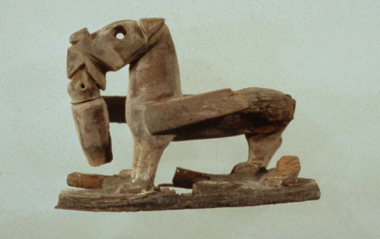 A carving of a dog holding something in its mouth.