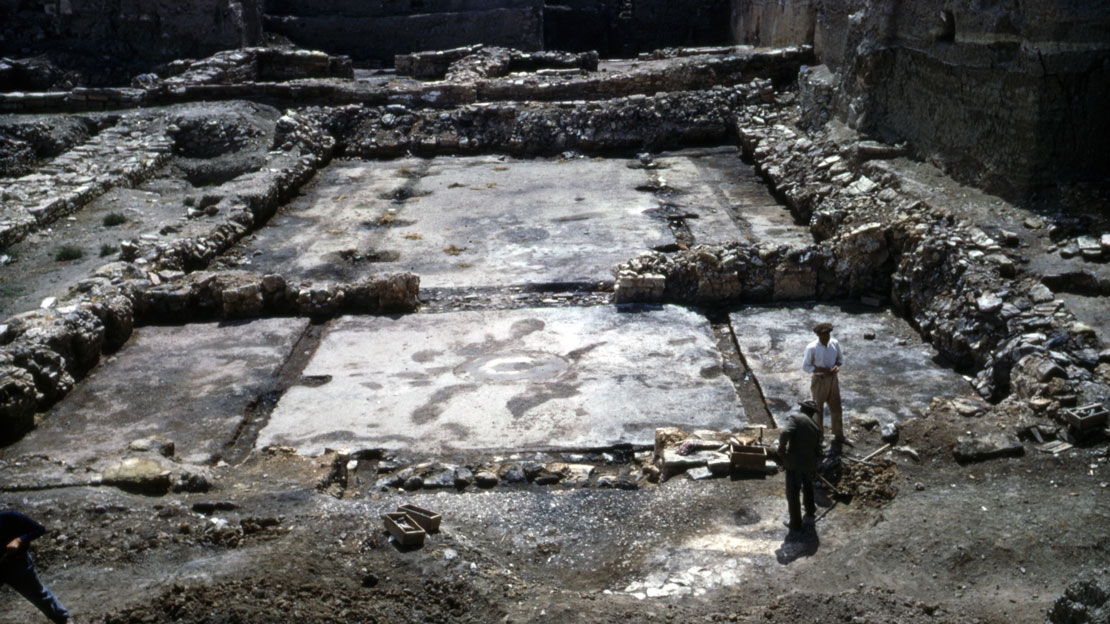 An excavated building foundation showing the location of walls and rooms from stone walls.