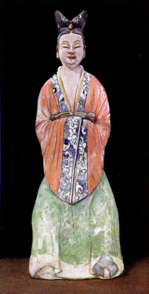 Painted pottery figure of a princess with red long sleeve top, green skirt, and hands clasped together in front obscured by long sleeves