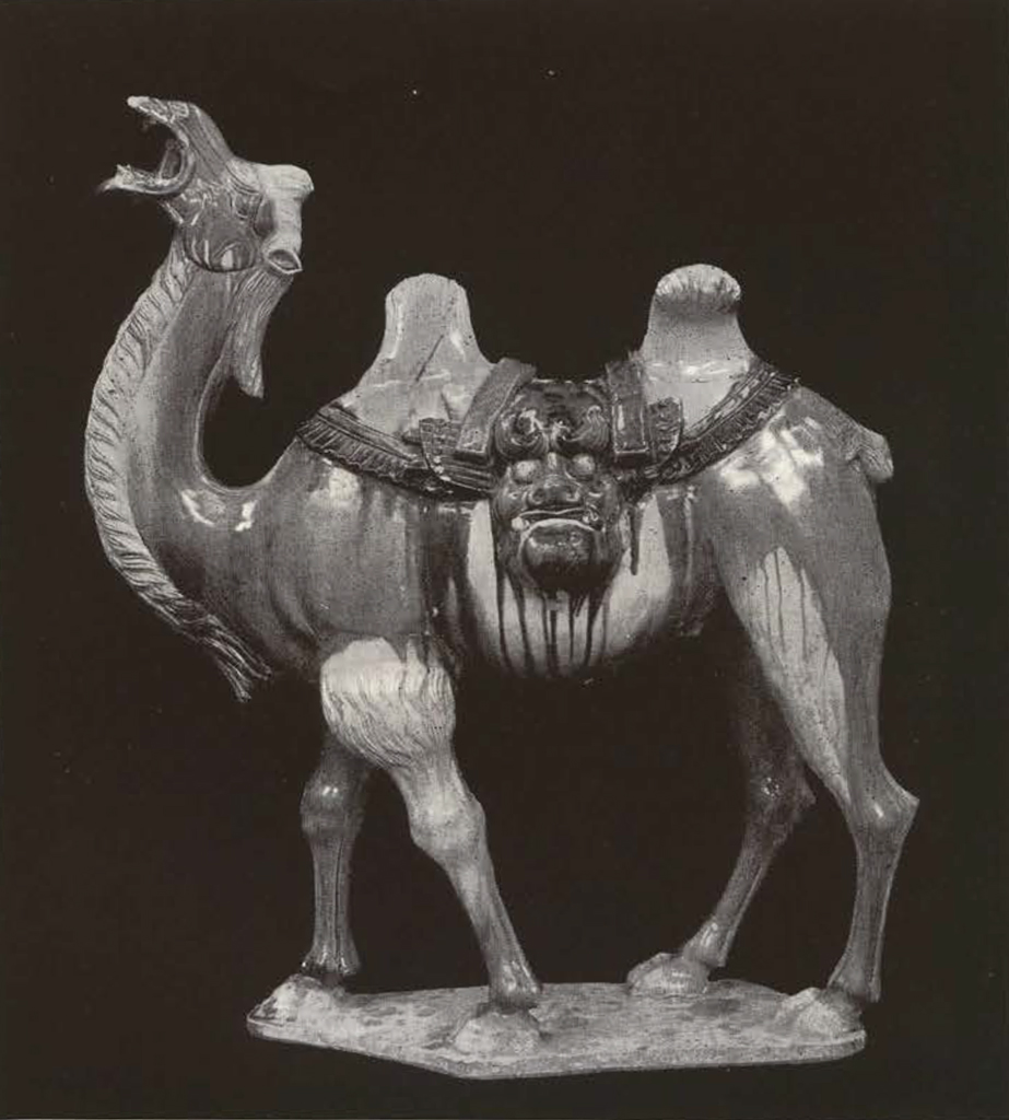 Glazed clay figure of two humped standing camel with neck up and mouth open, pack in face shape in-between the humps