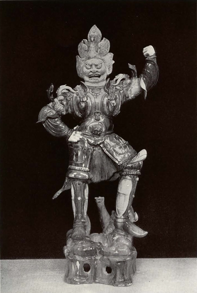 Lokapala figure with left arm raised with five pronged headdress, crushing a smaller figure under left foot