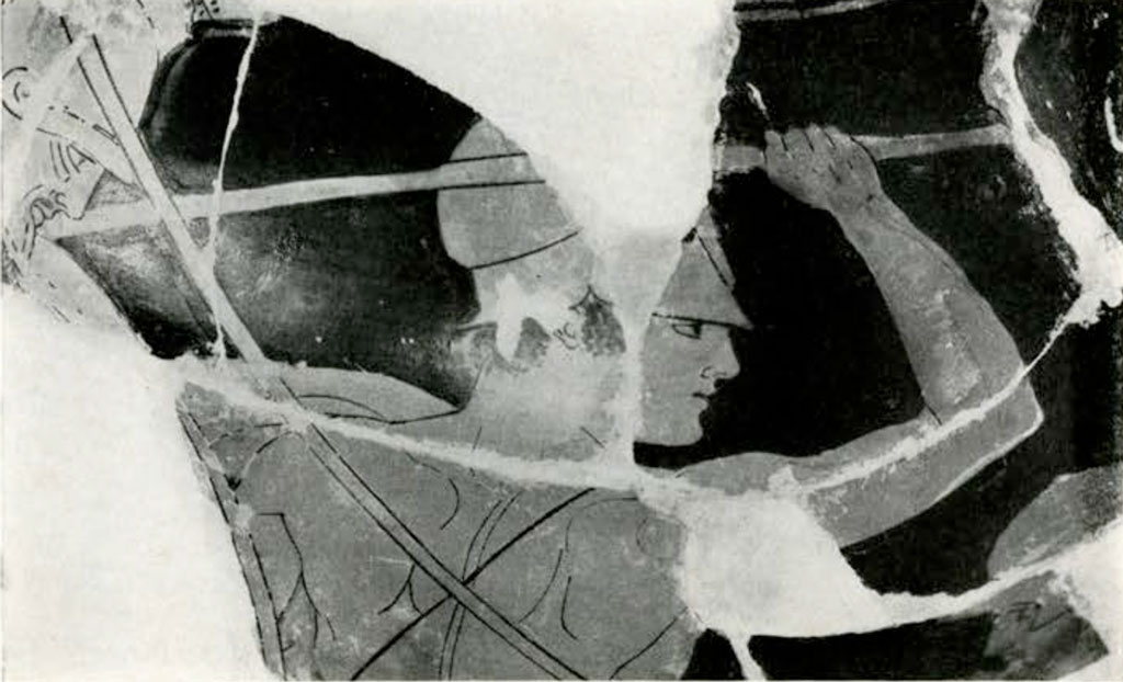 Close up of fragmented area from loutrophoros, showing a warrior's head and back, right arm a loft holding a spear, pieces missing