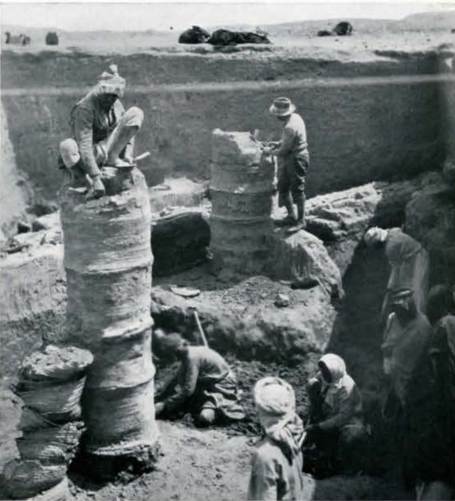 Men excavating columnar drain pipes, some on top of the pipes