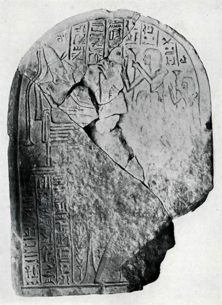 Stela with curved top showing carving of figures and hieroglyphs