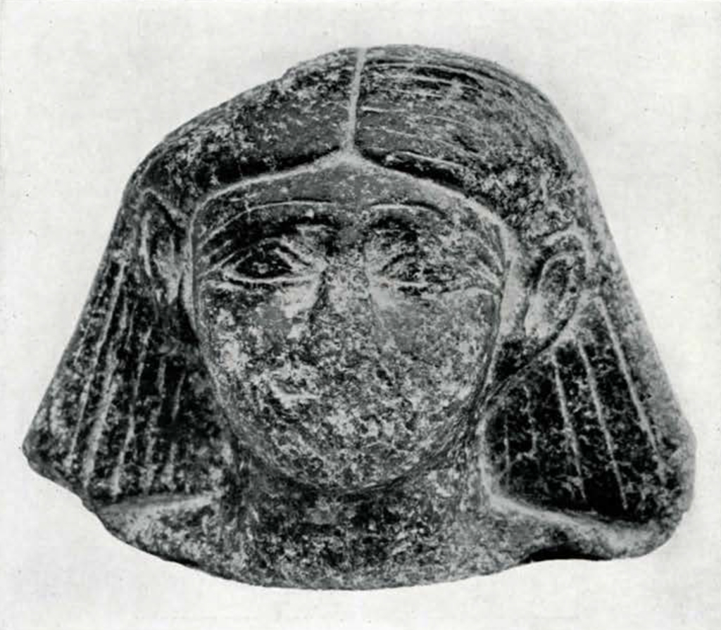Statue head with straight hair down to the shoulders, tucked behind the ears