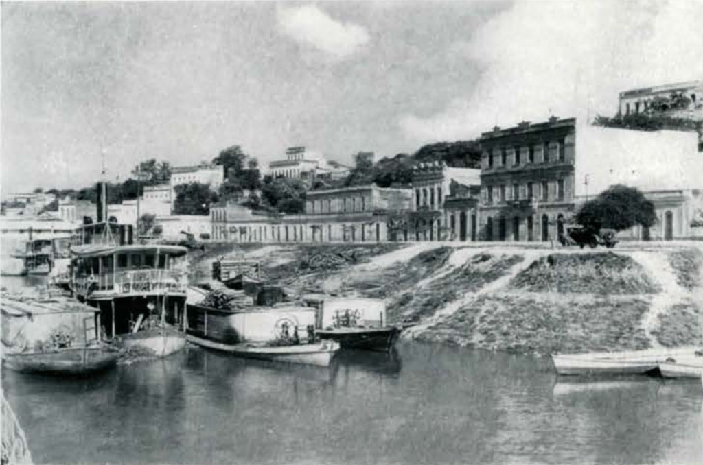 Boats along the river bank, which is lined with buildings