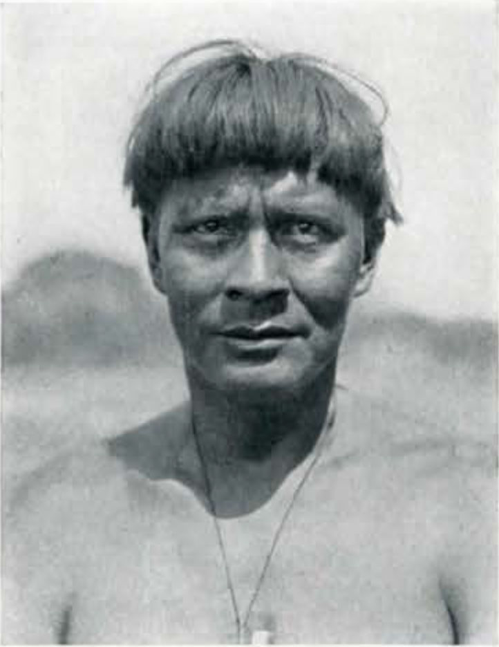 Portrait of a man with short hair and wearing a necklace