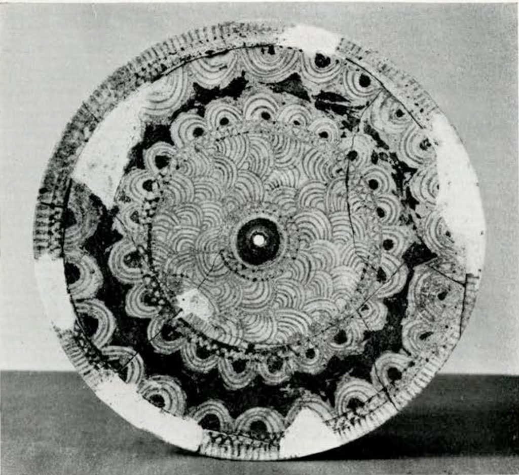 Lid of circular pyxis with concentric circle designs around the rim and handle