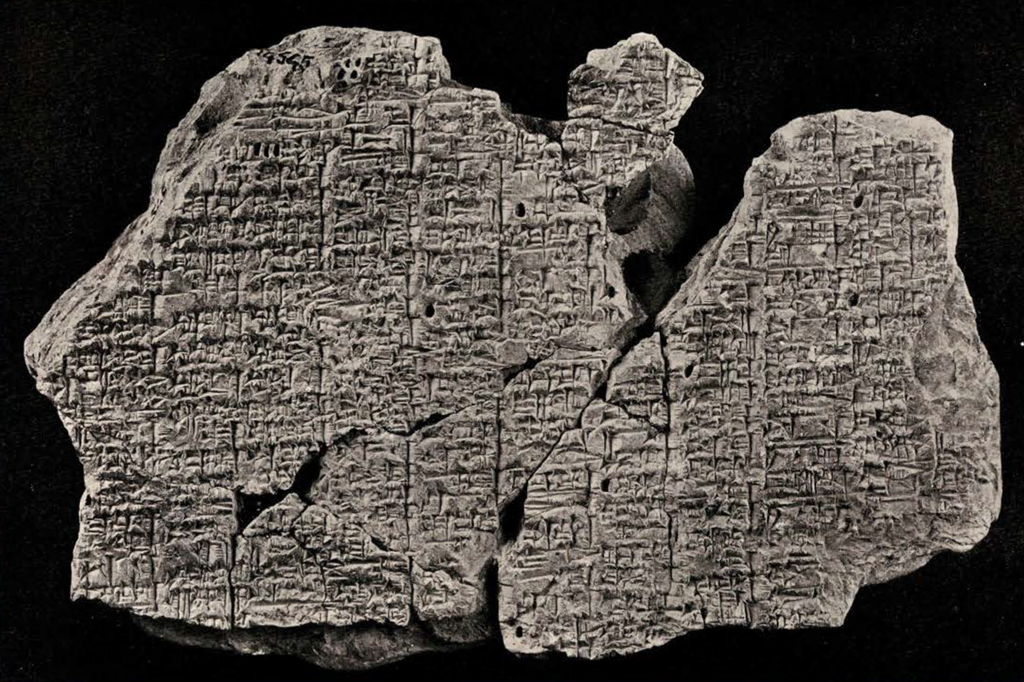 Fragments of a tablet pieced together showing many lines of cuneiform inscription