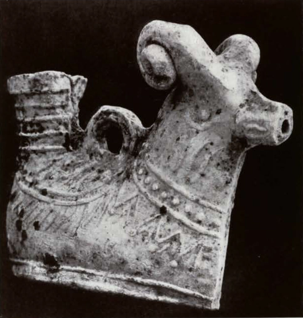 Vessel in the shape of a ram decorated to look like its wearing a harness