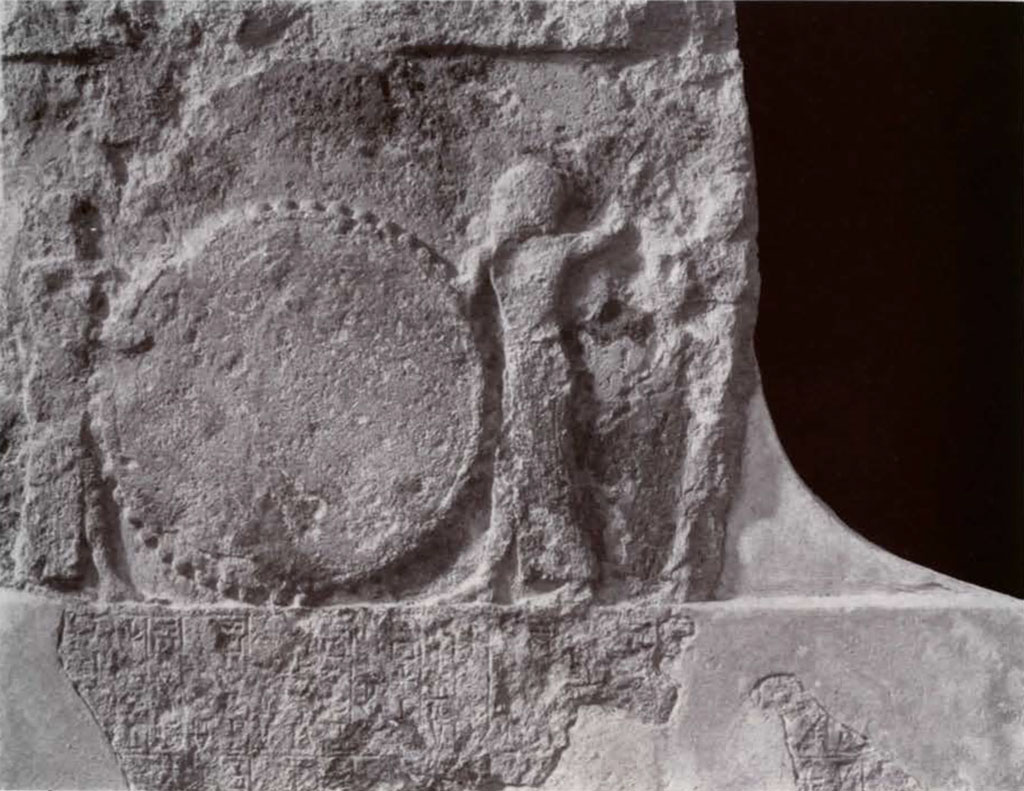 Fragment of a stela showing to figures beating a huge drum