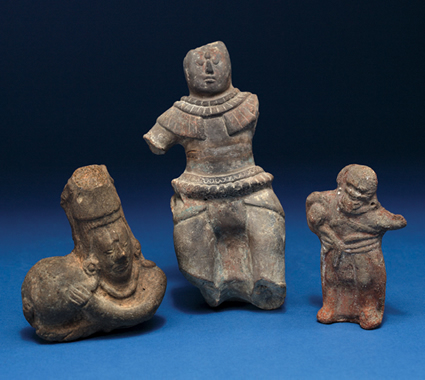 The pottery figurine fragment at left shows a ballplayer with a large ball (H: 10.9 cm, W: 9.53 cm, object NA 10942). The center figure, from Roknima, is dressed in protective hip pads (H: 19.3 cm, object NA 10975) and the pottery figurine fragment at right (H: 10.16 cm, object NA 11351) may have been a dwarf, with the small ball that was used near the Pacific coast. Phot by the Penn Museum.