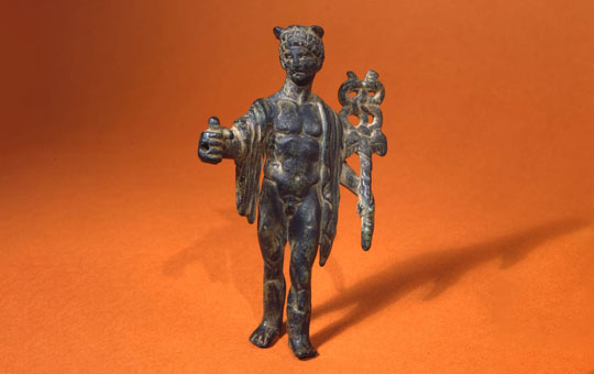Bronze figurine of Mercury with left foto and right hand extended, chlamys over both shoulders, holding a winged kerykeion in his left arm.